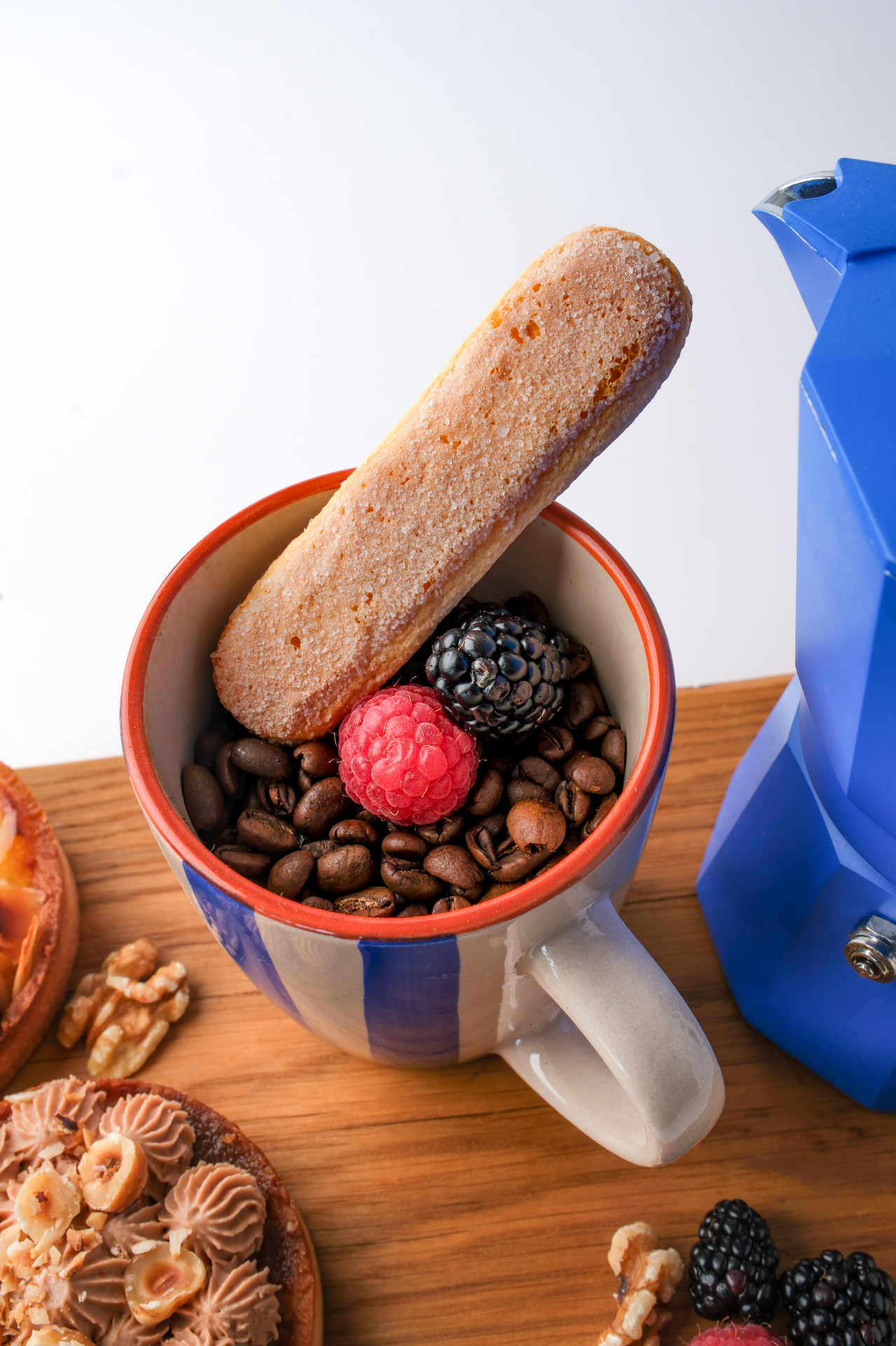 Tasse à café, biscuit cuiller et fruits rouges à la boutique L'Alchi Pâtissière